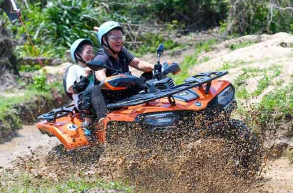 Tourists ride an all-terrain vehicle in Xitou village.