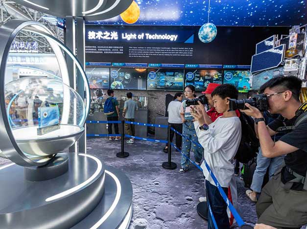 Visitors take photos of lunar samples collected by the Chang'e-6 mission from the moon's far side, on display at the 15th China International Aviation and Aerospace Exhibition in Zhuhai, south China's Guangdong province.