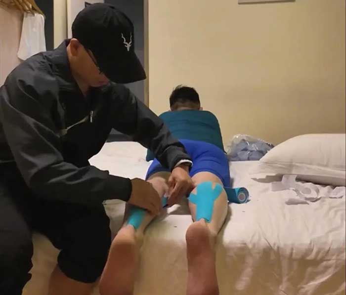 A running companion supports a participant in relaxing before a marathon. 