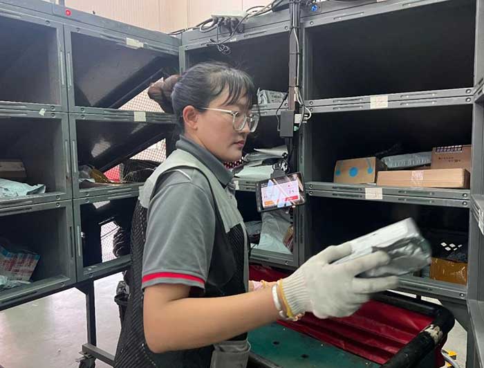 A worker sorts parcels with a smart cabin in a transfer center of SF Express in Lhasa, southwest China's Xizang autonomous region.