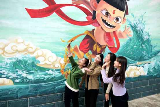 Several women pose for a picture in front of a mural depicting scenes from the Chinese animated blockbuster "Ne Zha 2" in Huimin county, Binzhou, east China's Shandong province.