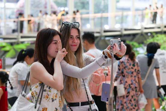 Tourists pose for a picture at a shopping center in southwest China's Chongqing municipality. 